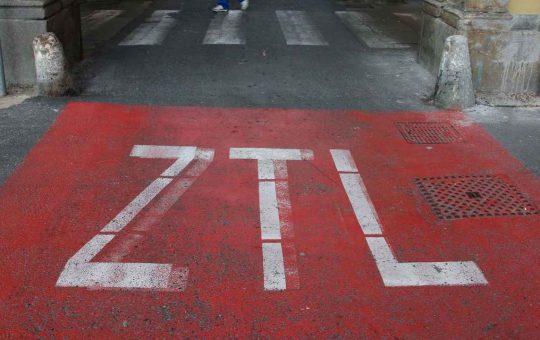 Fai attenzione, se non te ne accorgi subito l'accesso alla ZTL potrebbe costarti molto caro. Sono sempre più diffuse, richieste e - forse - allo stesso tempo odiate. Le Zone a Traffico Limitato, acronimo di ZTL, rappresentano una grande risorsa un po' per tutte le città, ma diciamocelo chiaramente: a volte possono essere una grande rottura. Pensiamo per esempio a quei turisti che entrano per la prima volta nel centro urbano con la propria macchina e non si accorgono di essere finiti in un tratto stradale off limits. In questi casi l'errore potrebbe costare caro, ma è comunque evitabile. Che cos'è e come fare per non farsi fregare La ZTL è un'area urbana delimitata da telecamere e sensori - con apposite segnalazioni stradali - con lo scopo di limitare il più possibile la circolazione in alcune ore del giorno e più volte alla settimana. L'obiettivo di chi decide di installarne una è quella di migliorare la qualità dell'aria, oltra alla vita dei residenti della zona e della cittadinanza in generale. Ma spesso può causare disagi, soprattutto nei confronti degli automobilisti o motociclisti più distratti. Occhio al portafogli In linea generale possono accedere alla Zona a Traffico Limitato i residenti e colo che hanno un pass speciale, ma in molti casi il transito è permesso anche ai veicoli elettrici o ibridi. Per poter avere il bollino verde è necessario richiedere un permesso dal costo variabile in base al Comune e al tratto di strada interessata. Nonostante la ZTL deve essere obbligatoriamente segnalata da cartelli ben visibili, spesso c'è chi oltrepassa il varco pur non potendolo fare. Questo vuol dire andare in contro a multe anche piuttosto salate che possono andare anche oltre i 100€ e che dipendono dalla città in cui è stata commessa l'infrazione. Di solito la sanzione va da un minimo di 83 ad un massimo di 332€. Va da sé che il modo migliore per evitare di entrare in una zona in cui il traffico è limitato è quello di tenere gli occhi aperti quando si guida e fare attenzione alle segnalazioni stradali. Molte volte infatti i cartelli che ne segnalano la presenza sono accompagnati da semafori (rosso se la ZTL è attiva, verde se è inattiva) e da telecamere ben visibili. Tuttavia esistono delle app di navigazione che possono aiutare non poco in quanto sono in grado di segnalare all'automobilista le ZTL lungo il tragitto.